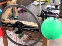 A bicycle wheel and balloon make up part of a Rube Goldberg machine. 