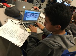 Student using a laptop and textbook