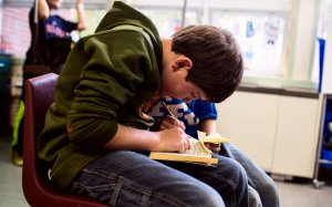 A student reads a book in his class.