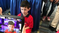 A young boy being filmed on a tablet for a video