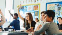 High school class with students raising hands.