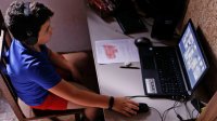 Elementary student working on his laptop at home