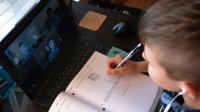 Boy completing math lesson via video chat during distance learning
