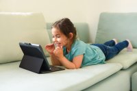 A kindergarten girl engages with learning via a tablet device