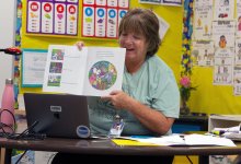 A second grade teachers reads to her students during virtual story time
