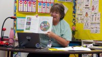A second grade teachers reads to her students during virtual story time