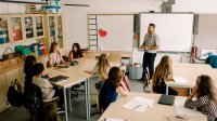 Middle school teacher talking to class from front of the classroom