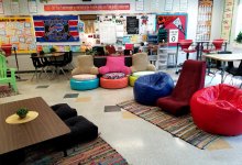 A flexible classroom with colorful, chairs, tables, carpets, and posters