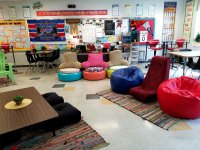 A flexible classroom with colorful, chairs, tables, carpets, and posters