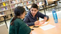 Two middle school students work on project in library at school