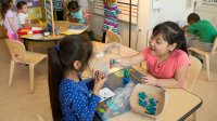 Two kindergarten students participate in an activity center together