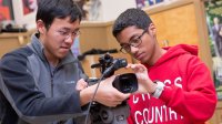 Two students operate a video camera