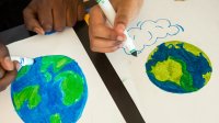 Two students draw the Earth with markers