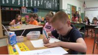 photo of a student writing at a desk