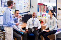 School teachers gather in a small school office for a chat. 