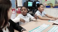 Students are talking to a teacher in a classroom