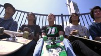 A group of teenagers are sitting down and holding their skateboards.