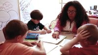 Teacher and a group of students are working together in a classroom.