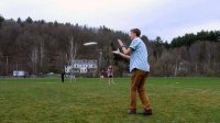 A group of students are hanging out and playing frisbee.