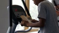 A student is doing an excercise while he is reading.