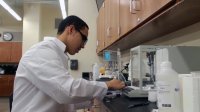 A high school student is working in a science lab.