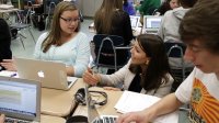 Teacher and a girl student are discussing about her work.