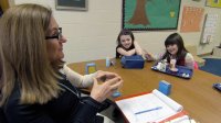 A teacher and students are working together in a working group setting.