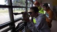 Student is looking through a camera in one of their field trip.