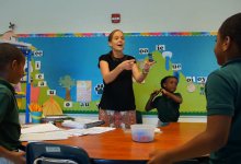 A teacher is working with her primary students in a classroom.