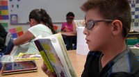 Student is reading a book in a classroom.