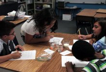 Students are observing on their work in the science class.