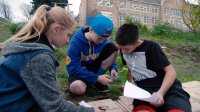 A group of students are helping each other to work on their group project.