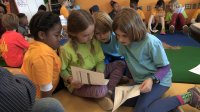 A group of primary school students are reading and working together.