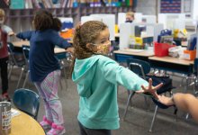 Students play a stretching game during a classroom break