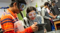 Two high school students use a tablet in science class