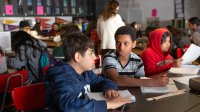 Elementary aged students in classroom working in small groups. 