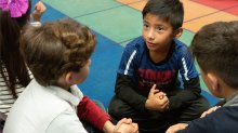 Students in elementary class talk in pairs and small groups. 