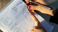 Student makes notes during outdoor science experiment