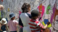 Elementary school children paint mural for a community project. 