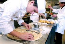 Young man prepares food in restaurant kitchen