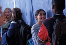 A group of students hanging out in a middle school hallway