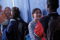 A group of students hanging out in a middle school hallway