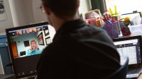 A social studies teacher participates in an online staff meeting alone in his classroom at Middletown High School