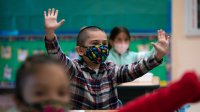 Elementary students stretching at their desks