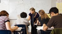 High school math teacher helps students during class