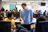 English teacher talks with students in classroom