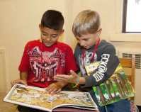 Two elementary school students reading books together