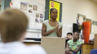 Middle school girl giving presentation in classroom at school