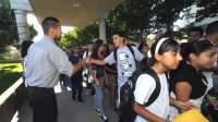 Teacher greets a student on the way into school