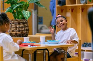 A child eats a meal with a classmate at Clayton Early Learning Center in Denver.